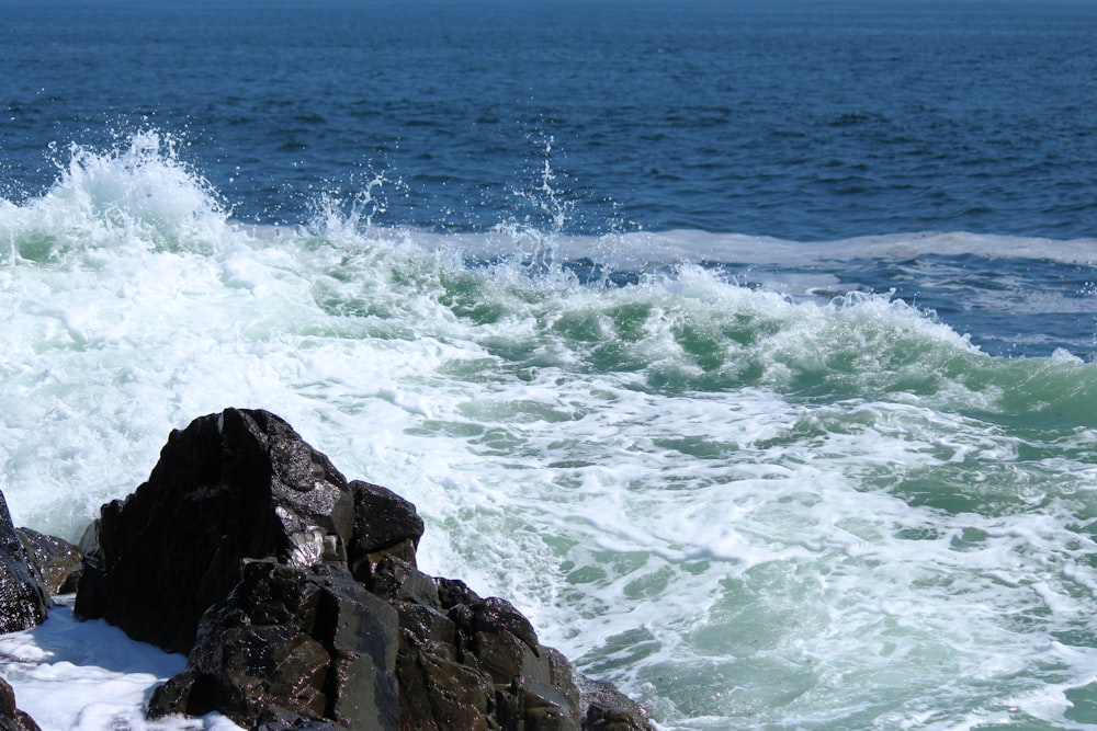 Les vagues de l’océan s’écrasent sur le rivage rocheux pendant la journée