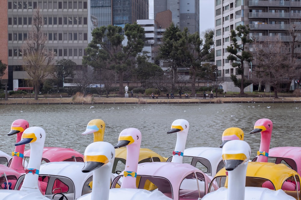 a row of colorfully painted pedal cars in front of a body of water