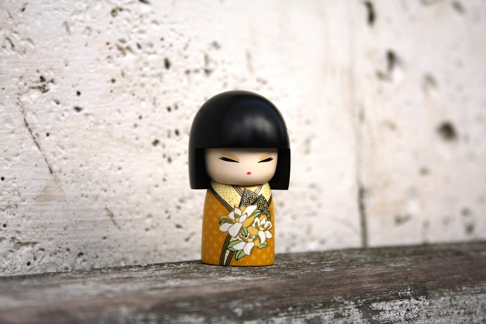 black haired woman in yellow and red floral dress figurine