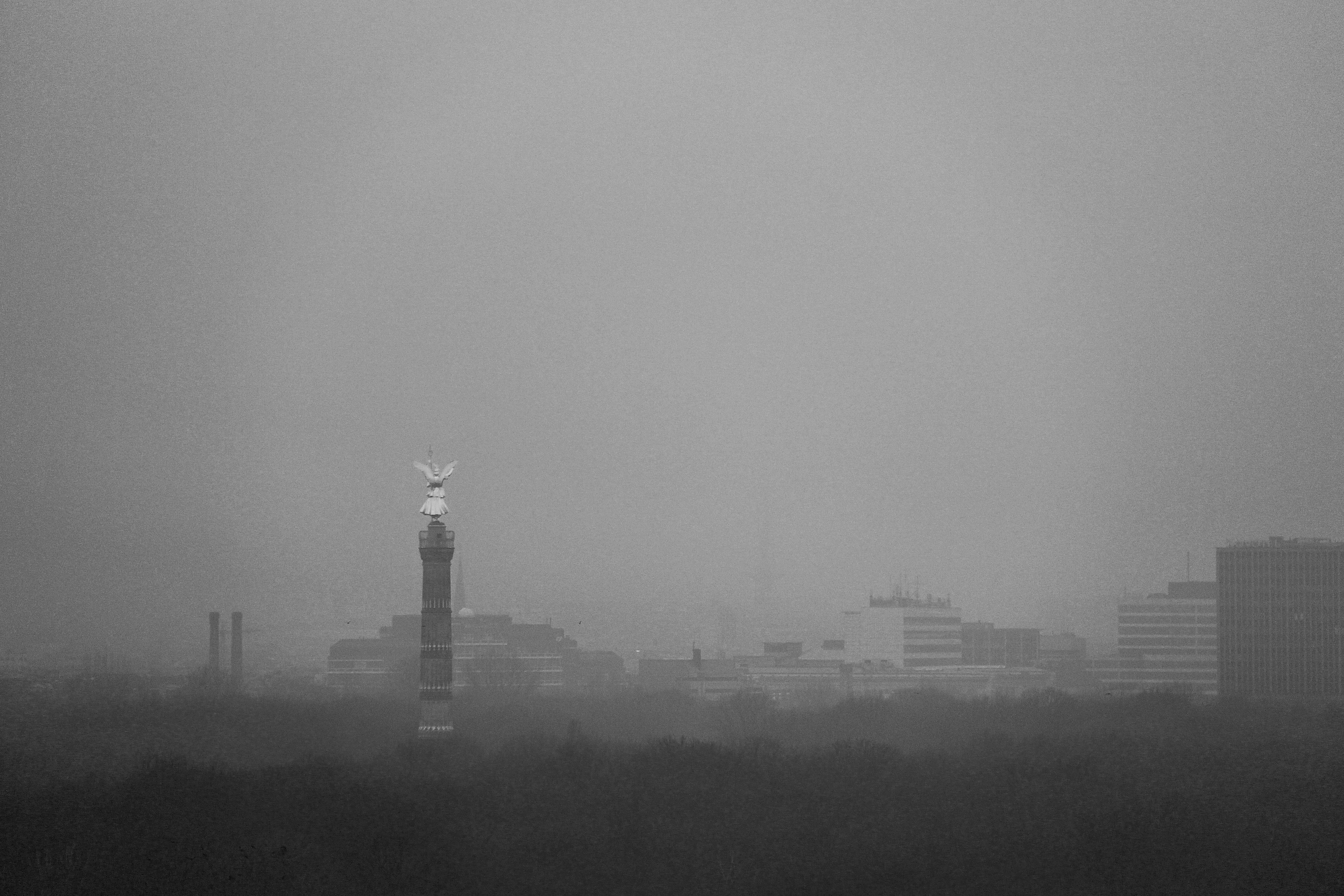 a black and white photo of a foggy city