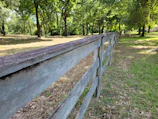 A freshly installed, sturdy wooden fence bordering a residential property on a sunny day.