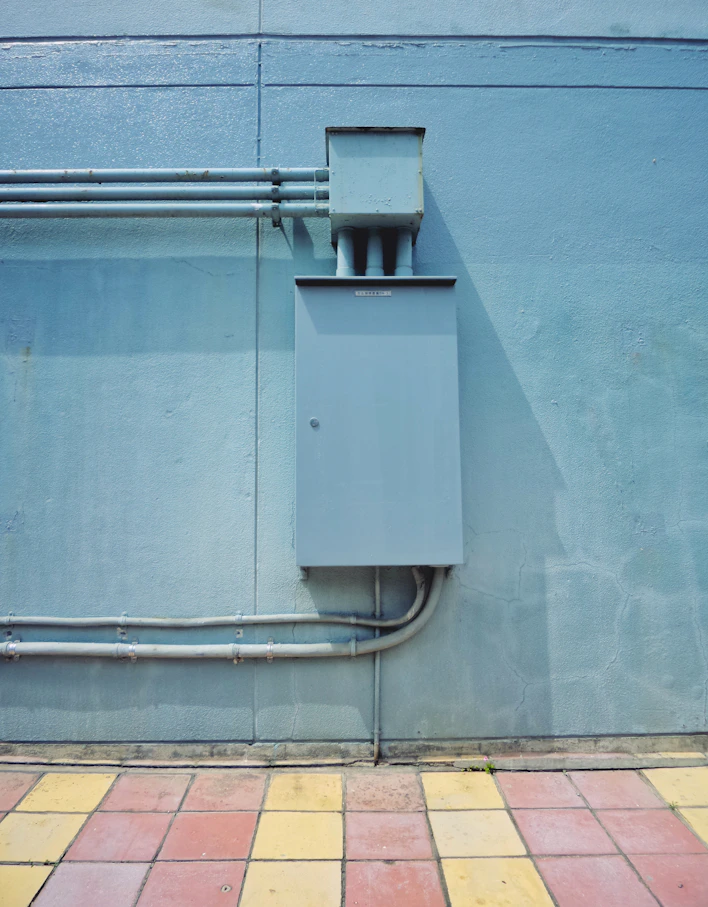 gray and black water heater mounted on blue wall