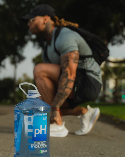 man in black and gray jacket sitting on brown wooden bench