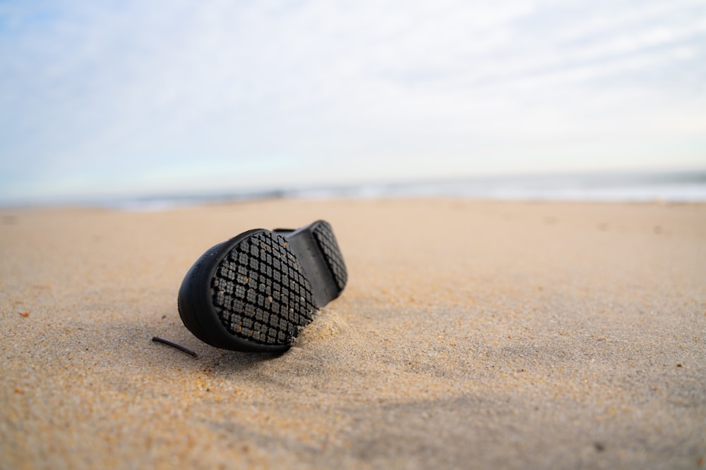 black and silver round watch on brown sand