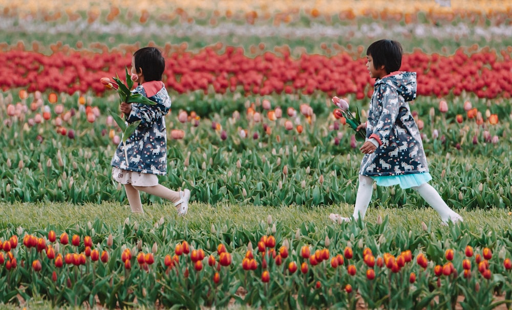 girl in blue and white floral dress walking on green grass field during daytime