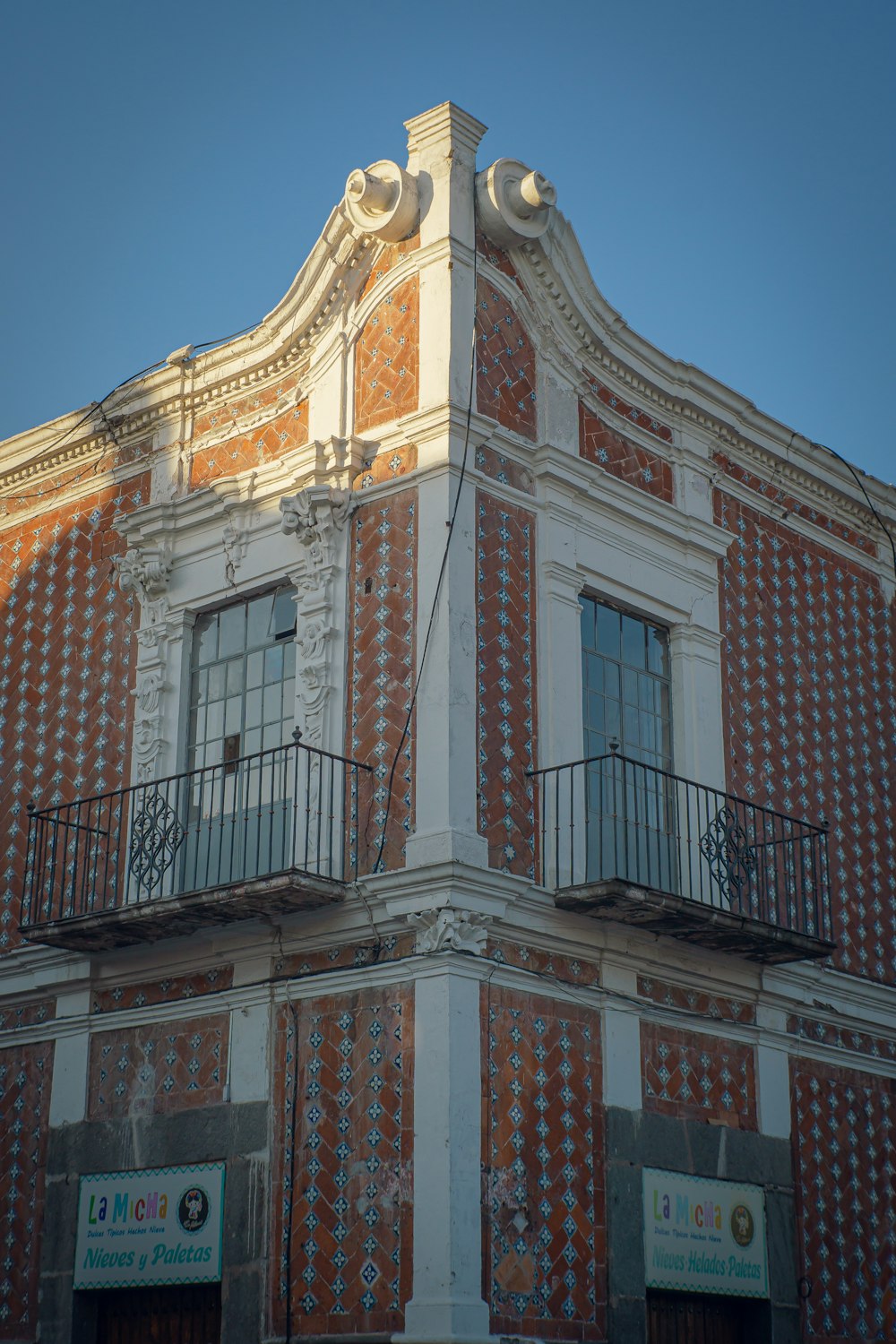 Edificio de hormigón marrón y blanco bajo el cielo azul durante el día