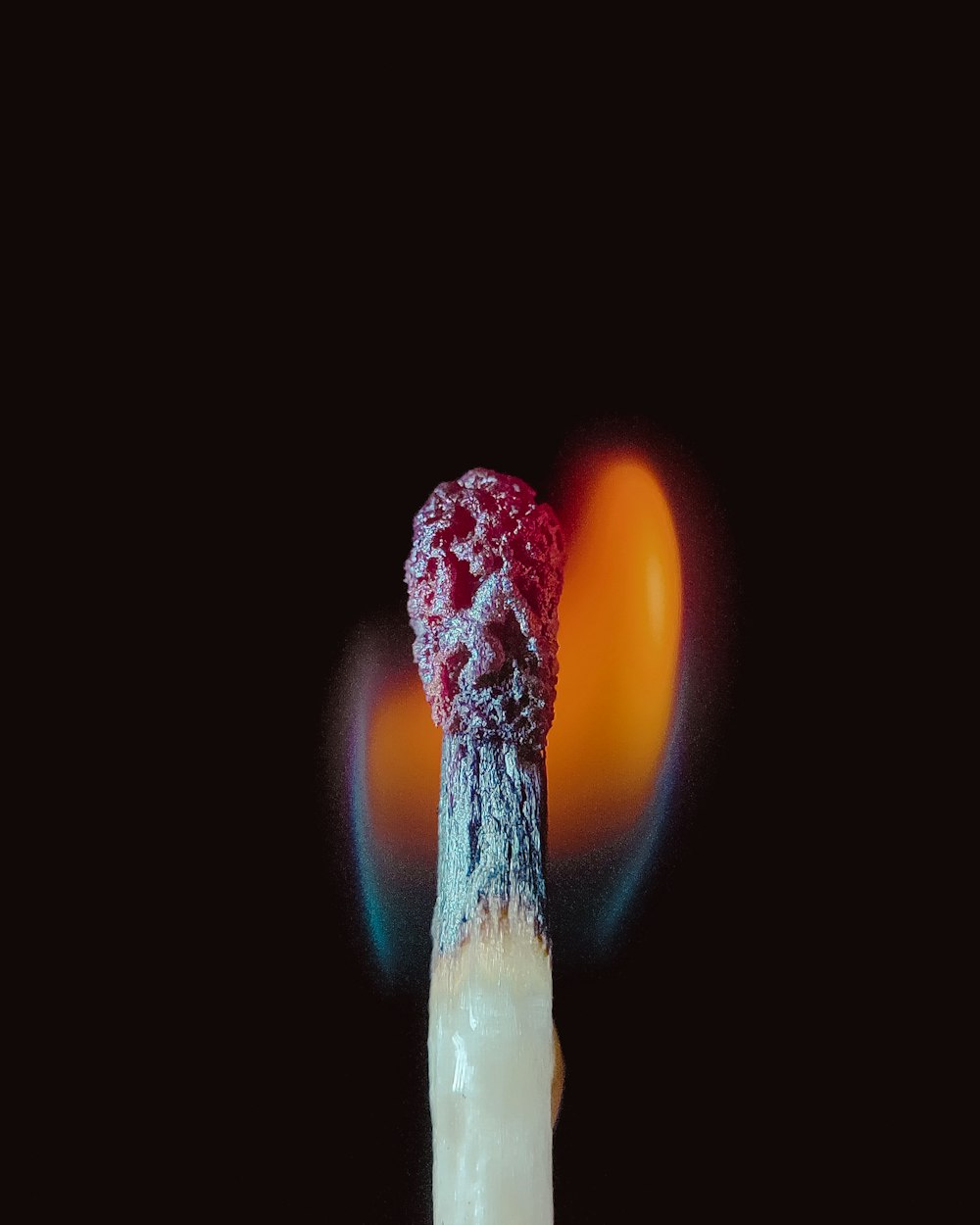 a lit cigarette with a red substance on top of it