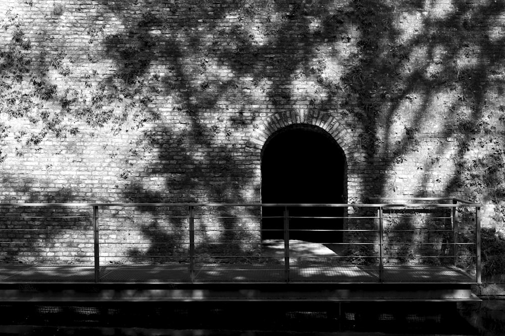 grayscale photo of arch shaped tunnel