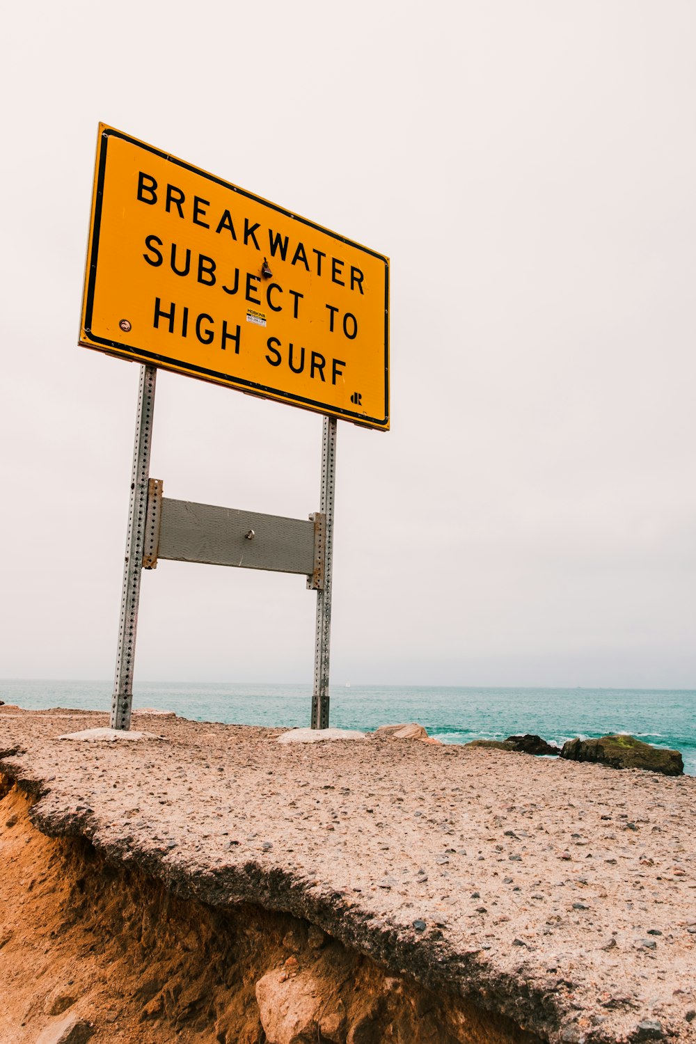 brown wooden signage on beach shore during daytime