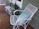 A cozy porch scene featuring a white farmhouse side table with a potted plant and a cup of coffee.