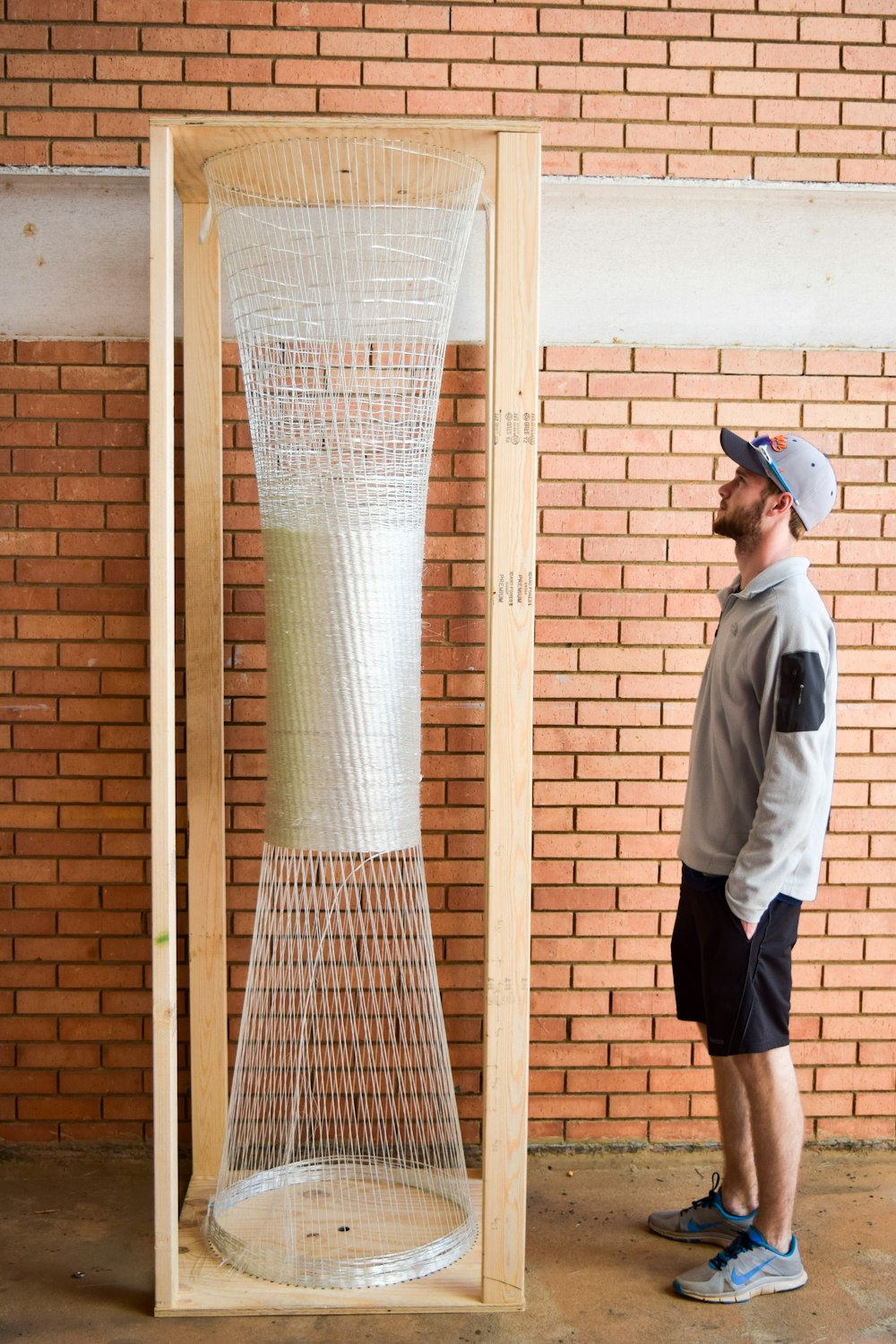 man in white shirt and black shorts holding white net