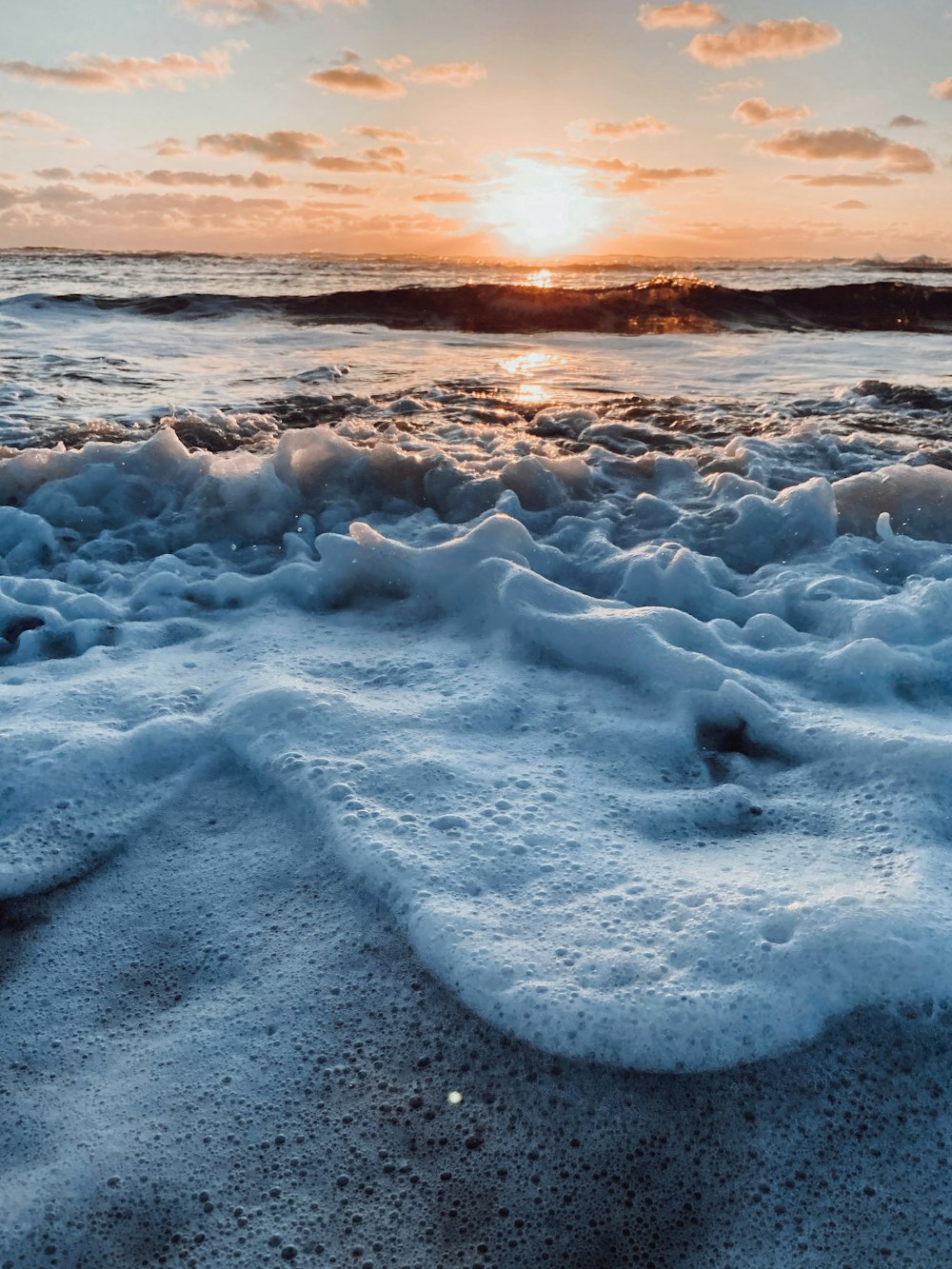 sea waves crashing on shore during sunset