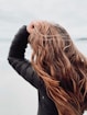 woman in black leather jacket covering her face with her hair