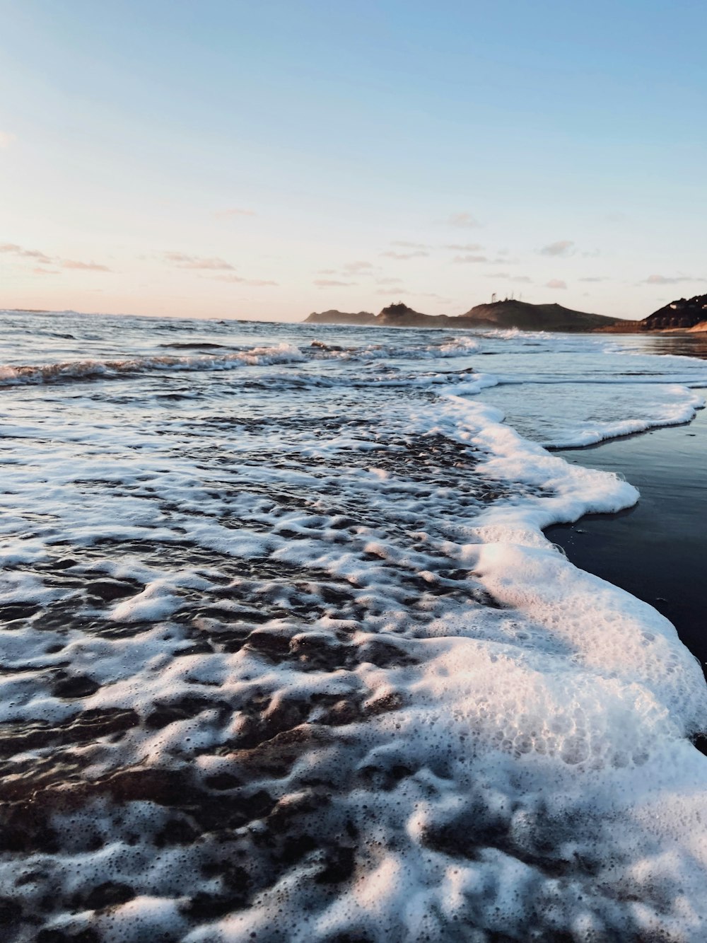 ocean waves crashing on shore during daytime