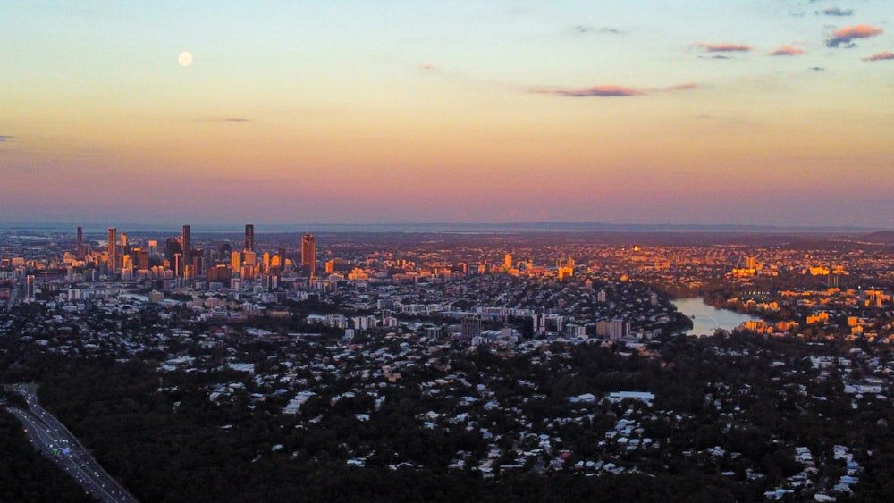 Skyline der Stadt unter orangefarbenem Himmel bei Sonnenuntergang