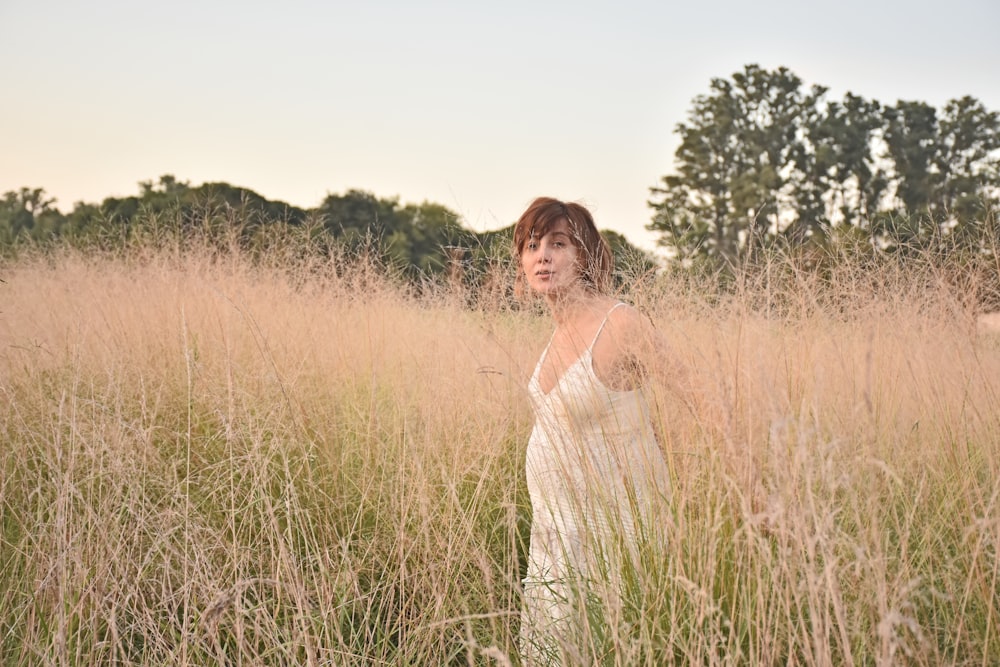 a woman standing in a field of tall grass