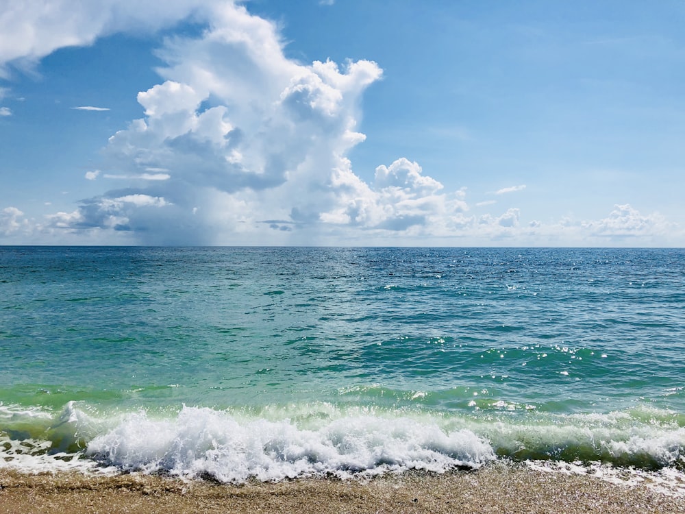 ocean waves crashing on shore during daytime