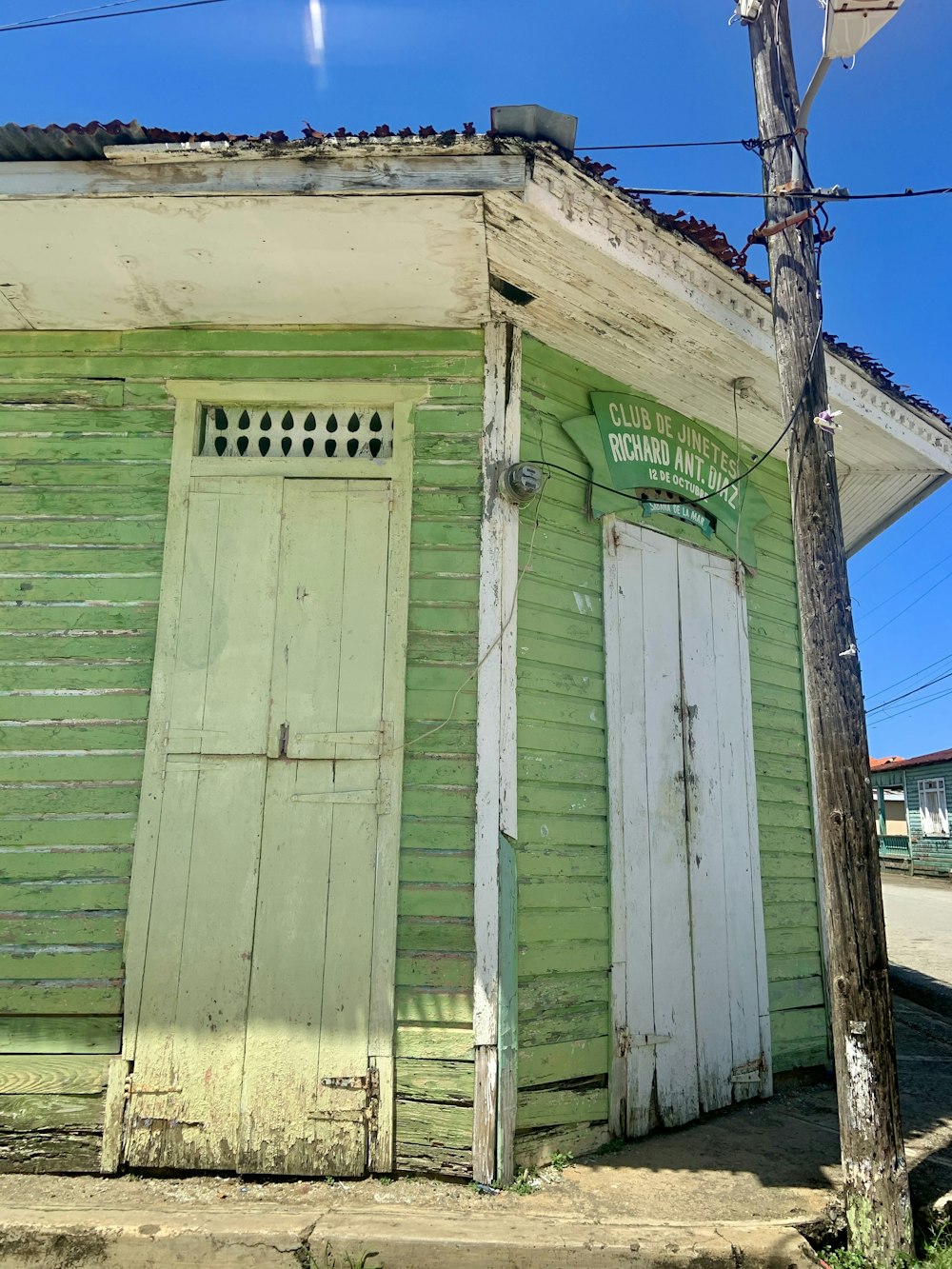 green wooden house under blue sky during daytime