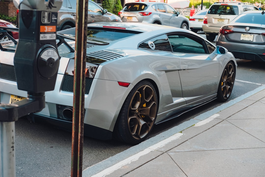 white coupe parked on sidewalk during daytime