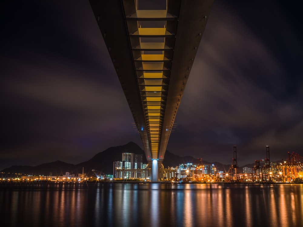 Puente iluminado sobre el cuerpo de agua durante la noche