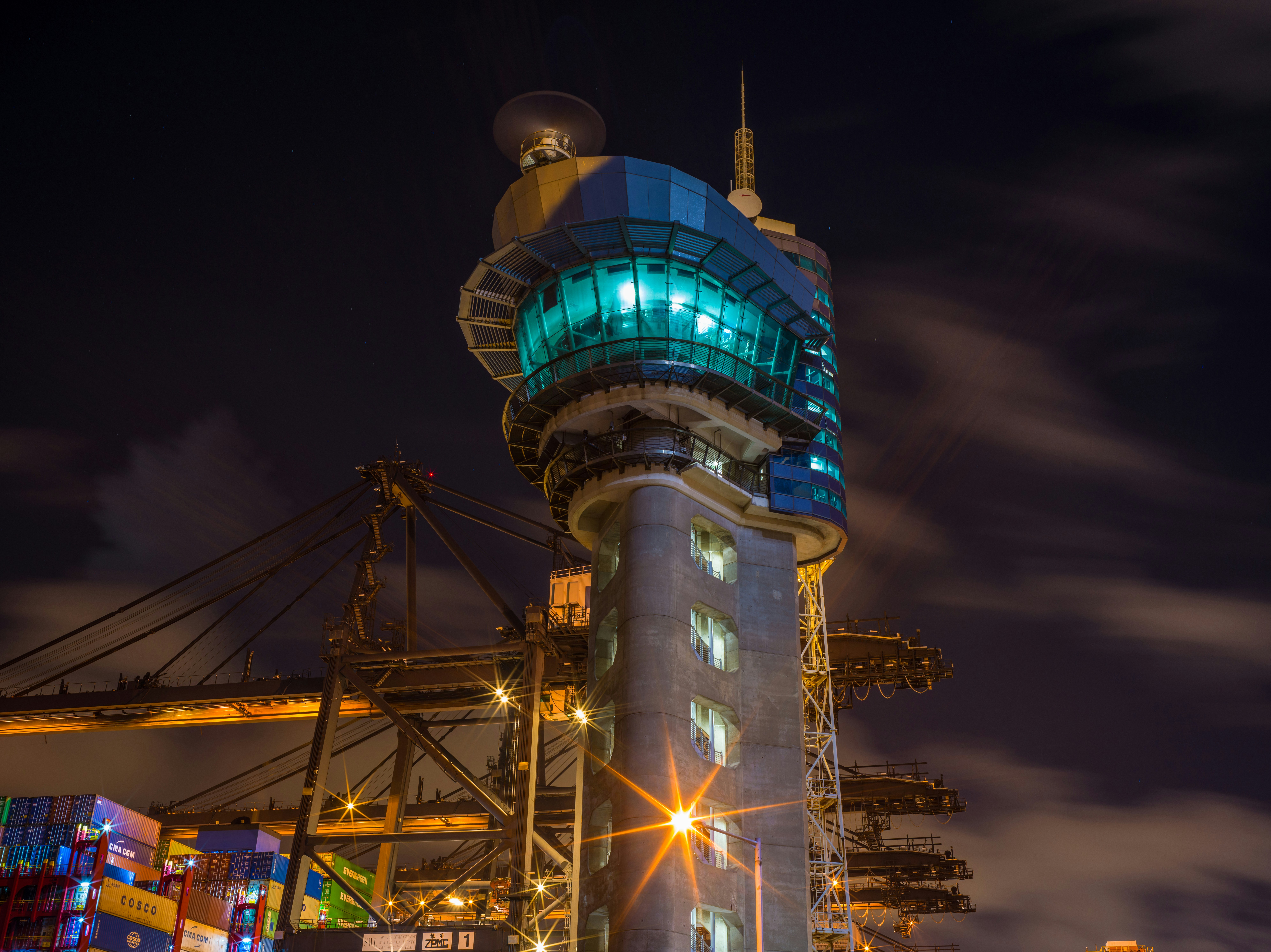 Modern aviation control tower at dusk, warm amber lighting, professional technical environment