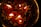 Floating candles are lit and surrounded by red rose petals and small white flowers, creating a warm and peaceful ambiance.