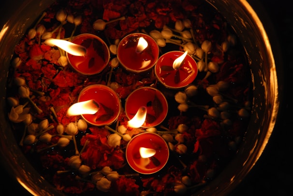 Floating candles casting warm golden light over swirling purple mist in a shadowy room.