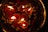 Floating candles are lit and surrounded by red rose petals and small white flowers, creating a warm and peaceful ambiance.