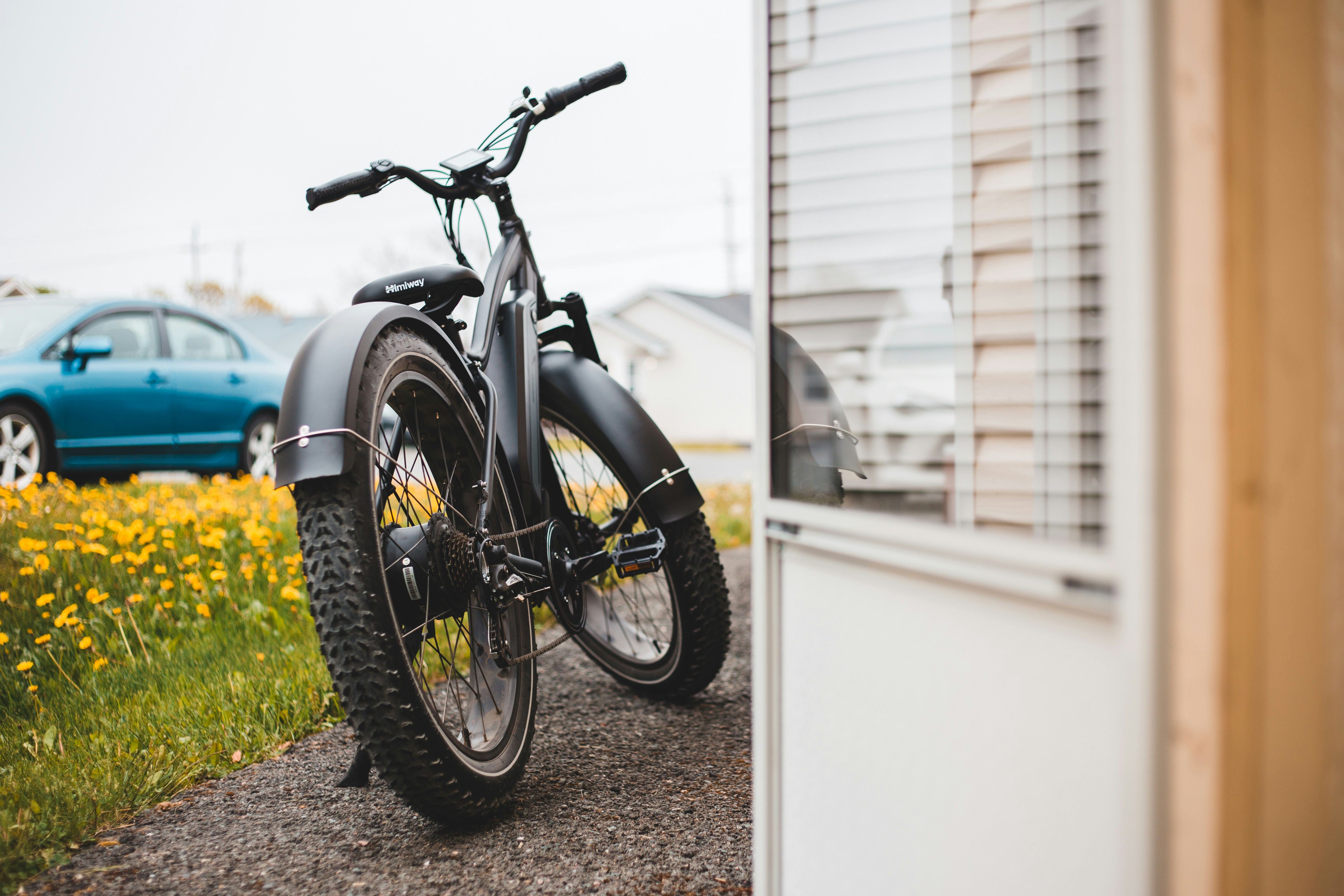 black and silver motorcycle parked beside white wall