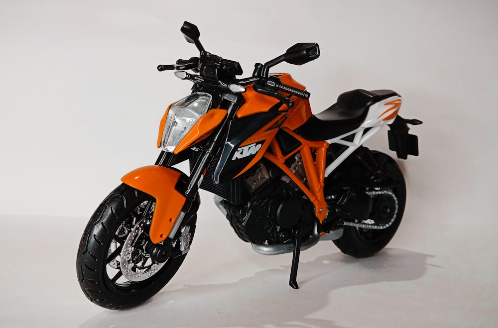 an orange and white motorcycle on a white background