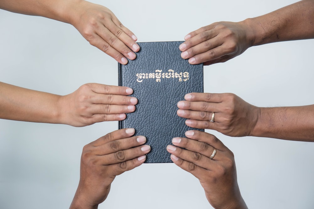 a group of people holding a book together