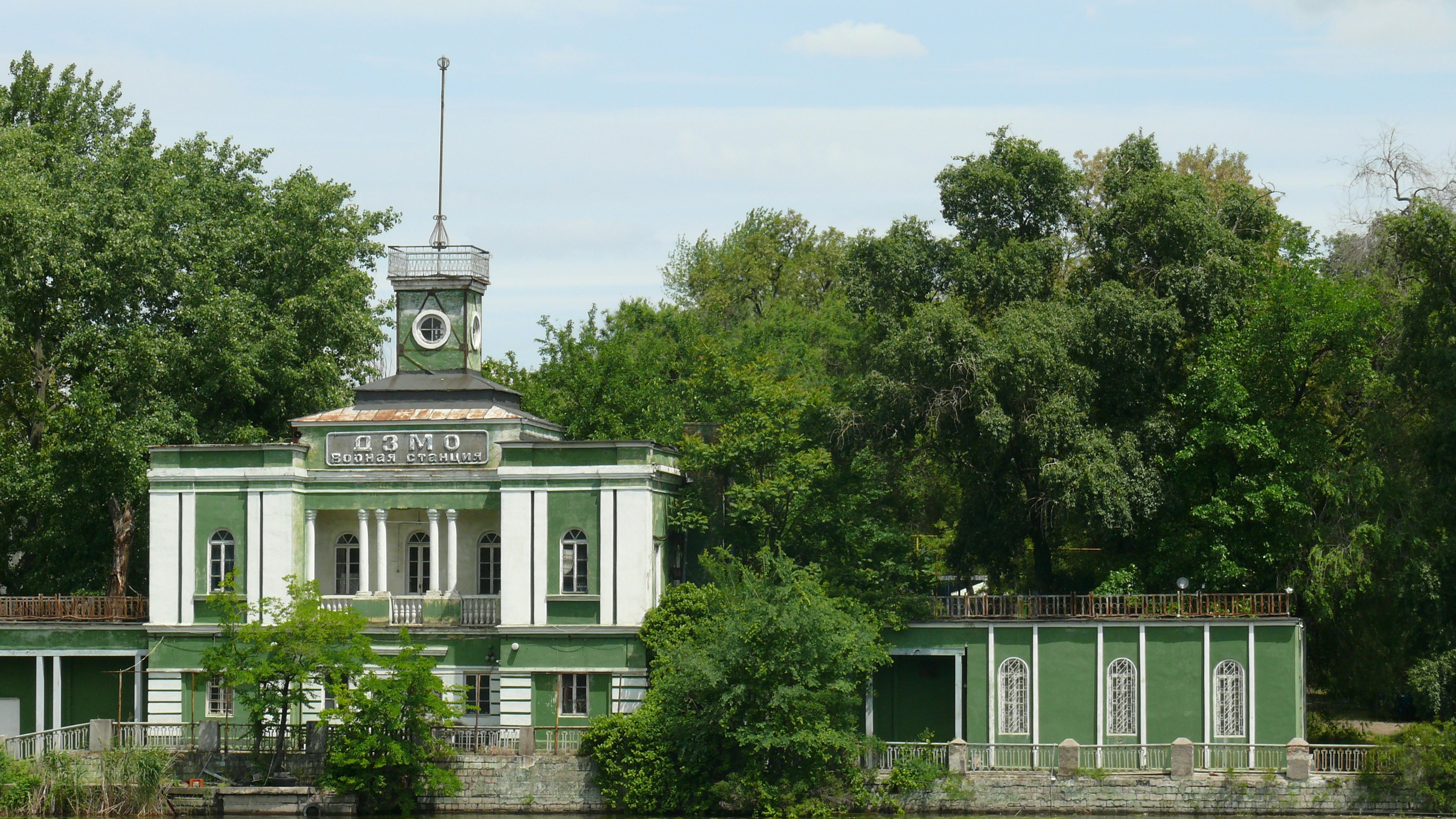 a green and white building with a clock tower