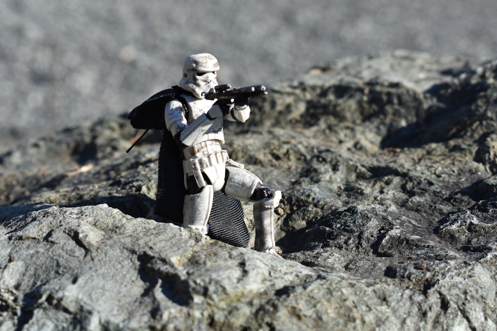 a star wars action figure sitting on a rock