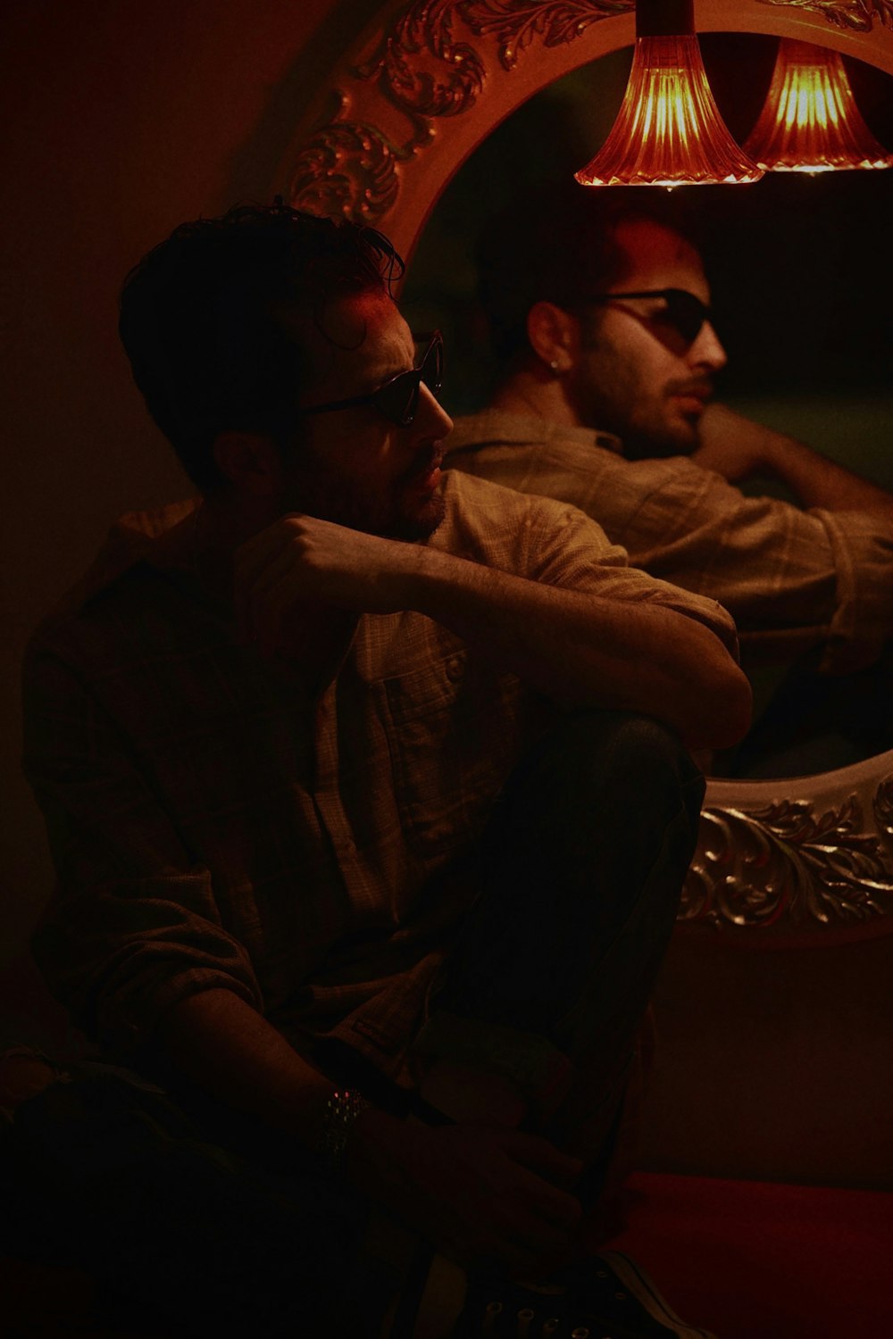 a man sitting in front of a mirror in a room