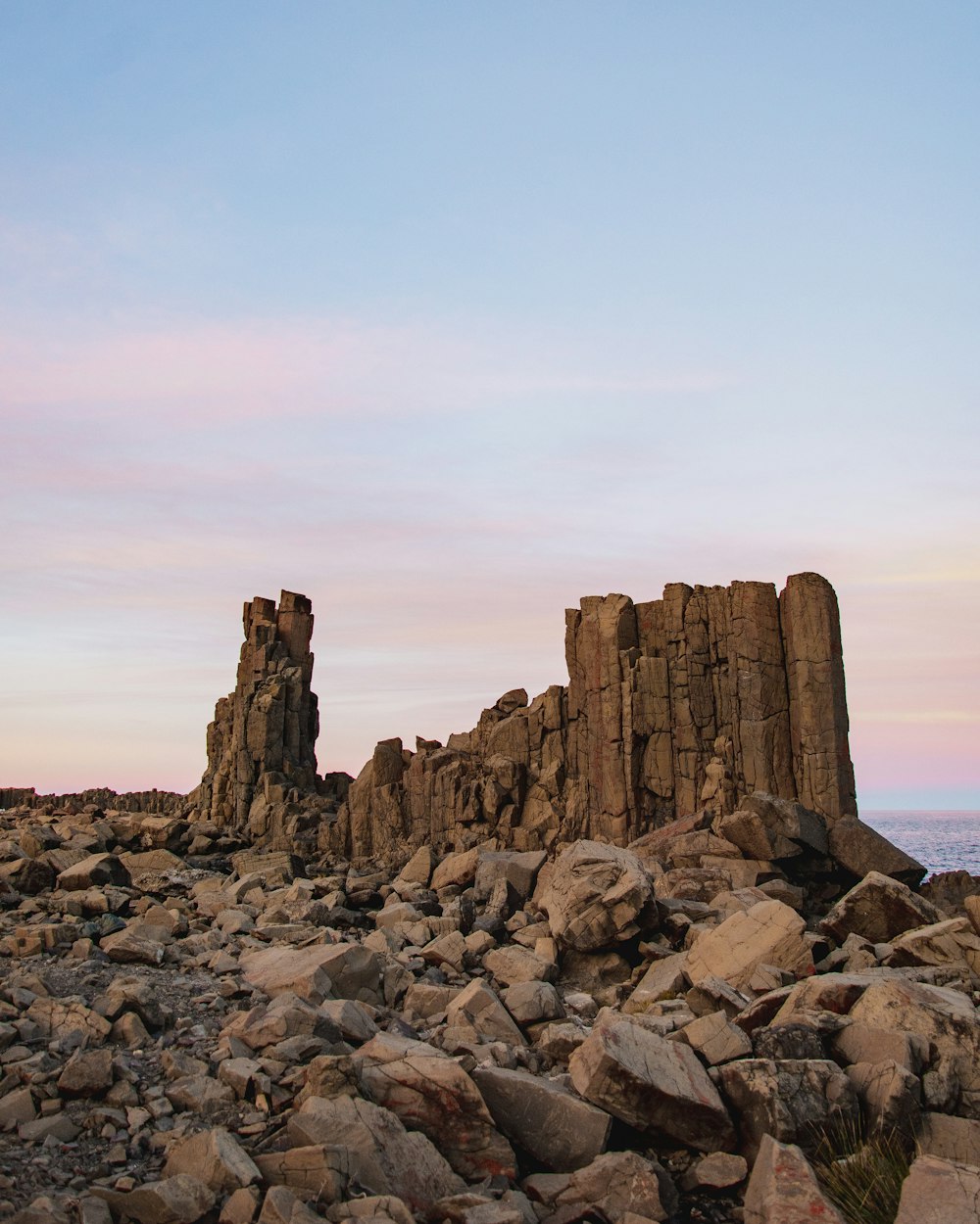 brown rock formation near body of water during daytime