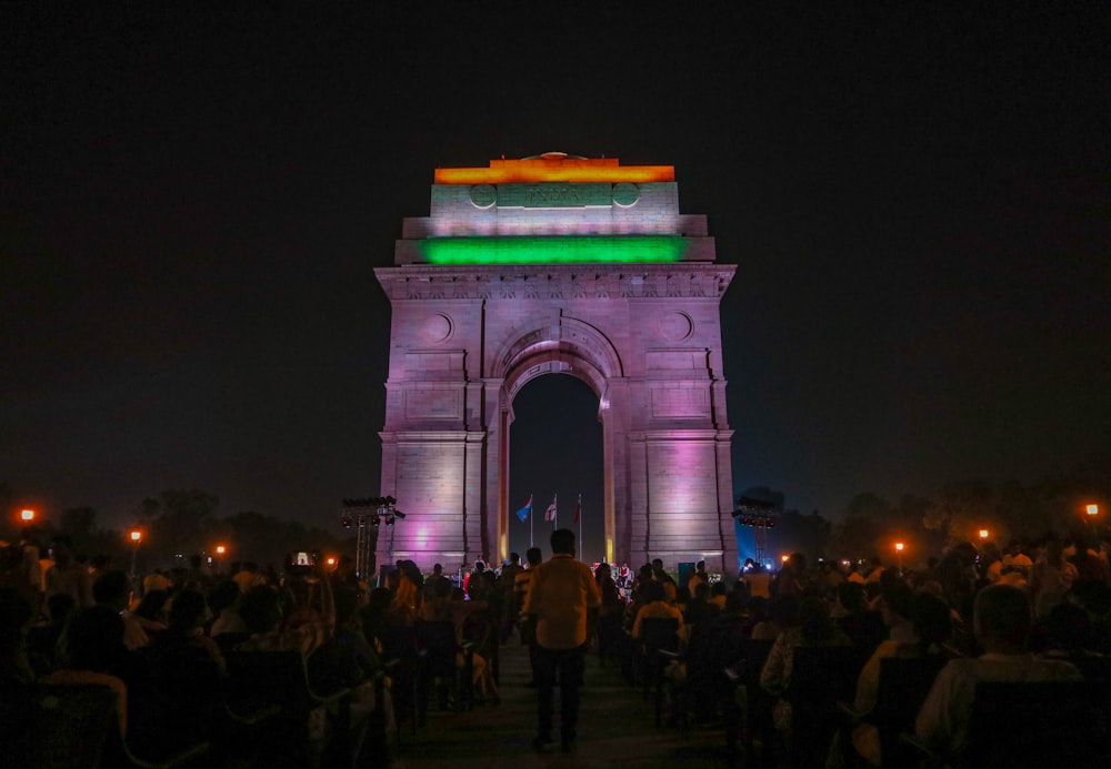 a crowd of people standing in front of a stone arch