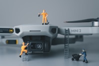 a couple of figurines standing on top of a camera