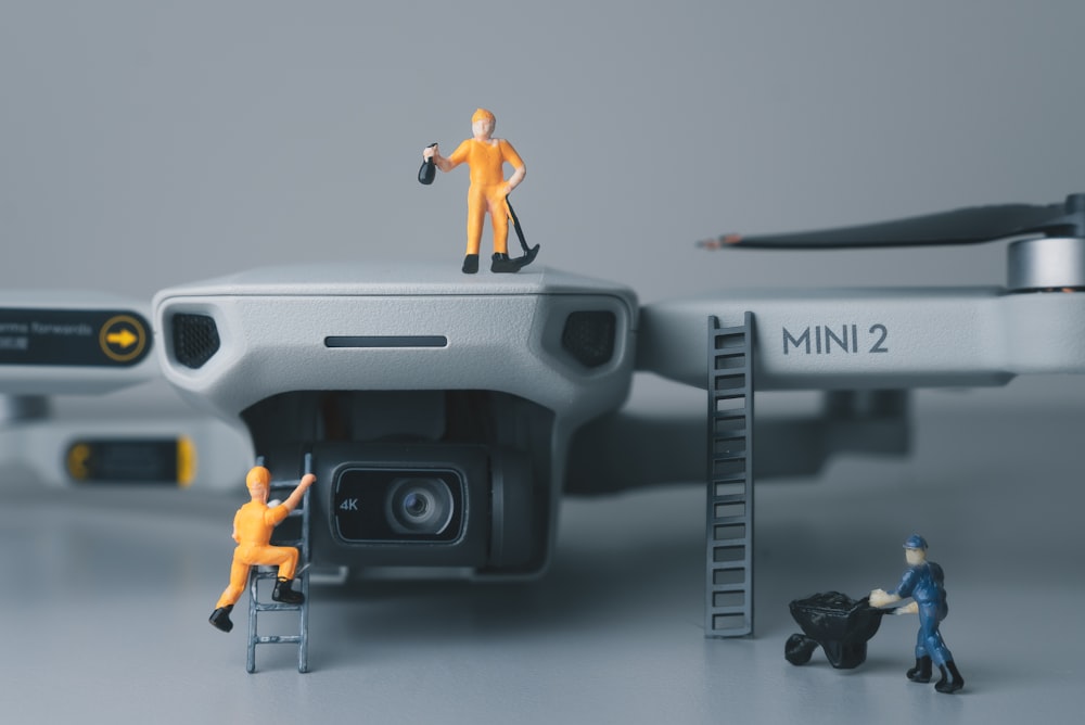 a couple of figurines standing on top of a camera