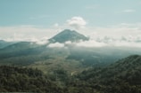 a view of a mountain range with clouds in the foreground