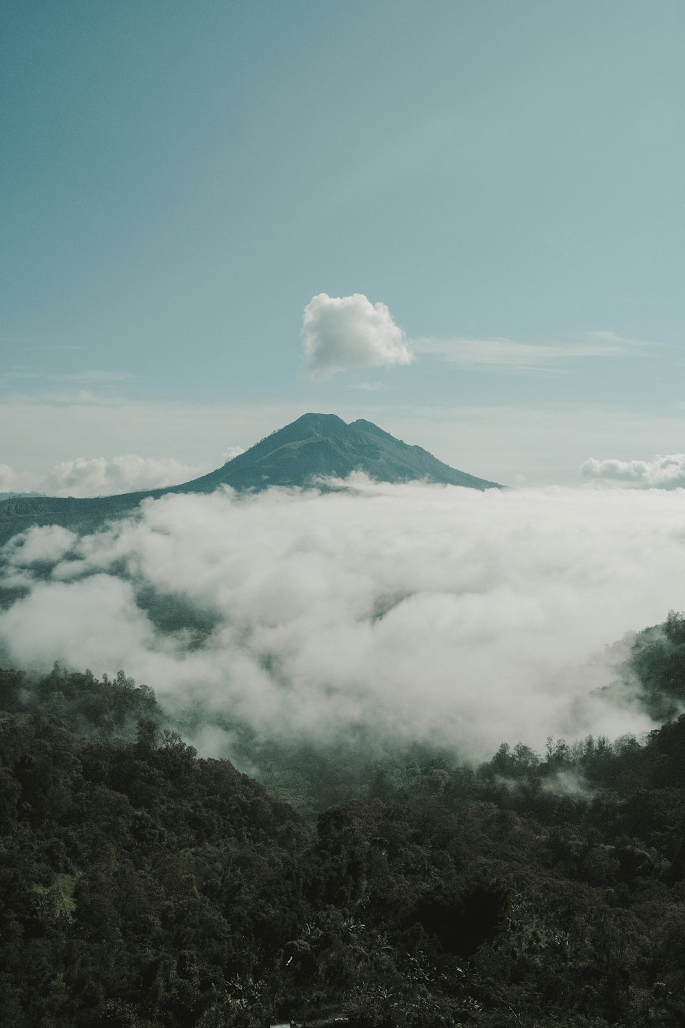 a mountain covered in clouds with a sky background