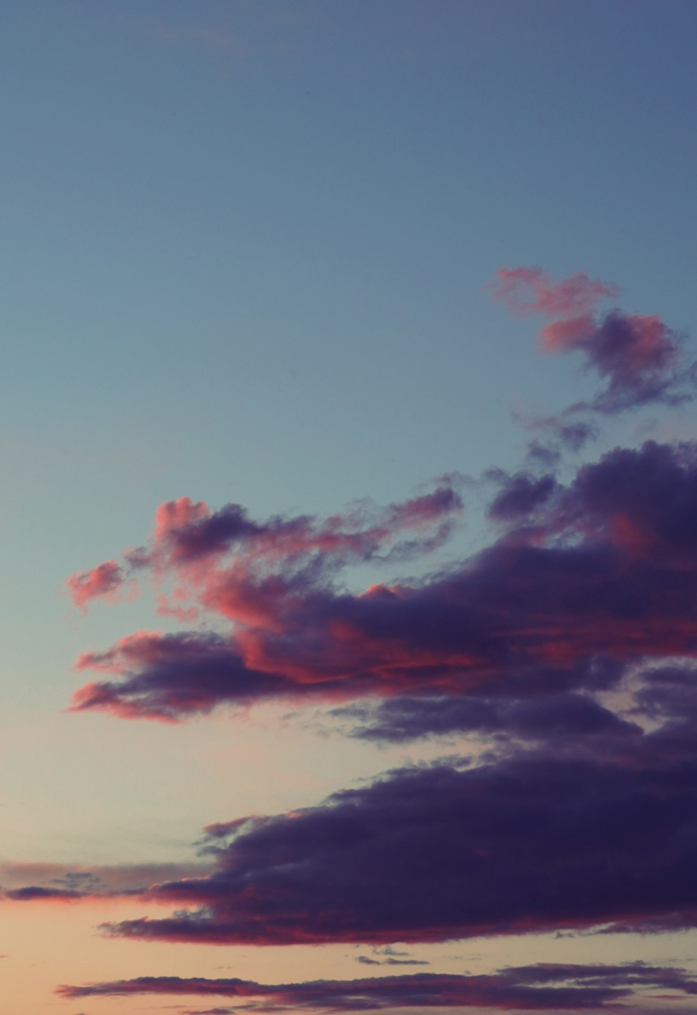 a plane flying in the sky at sunset