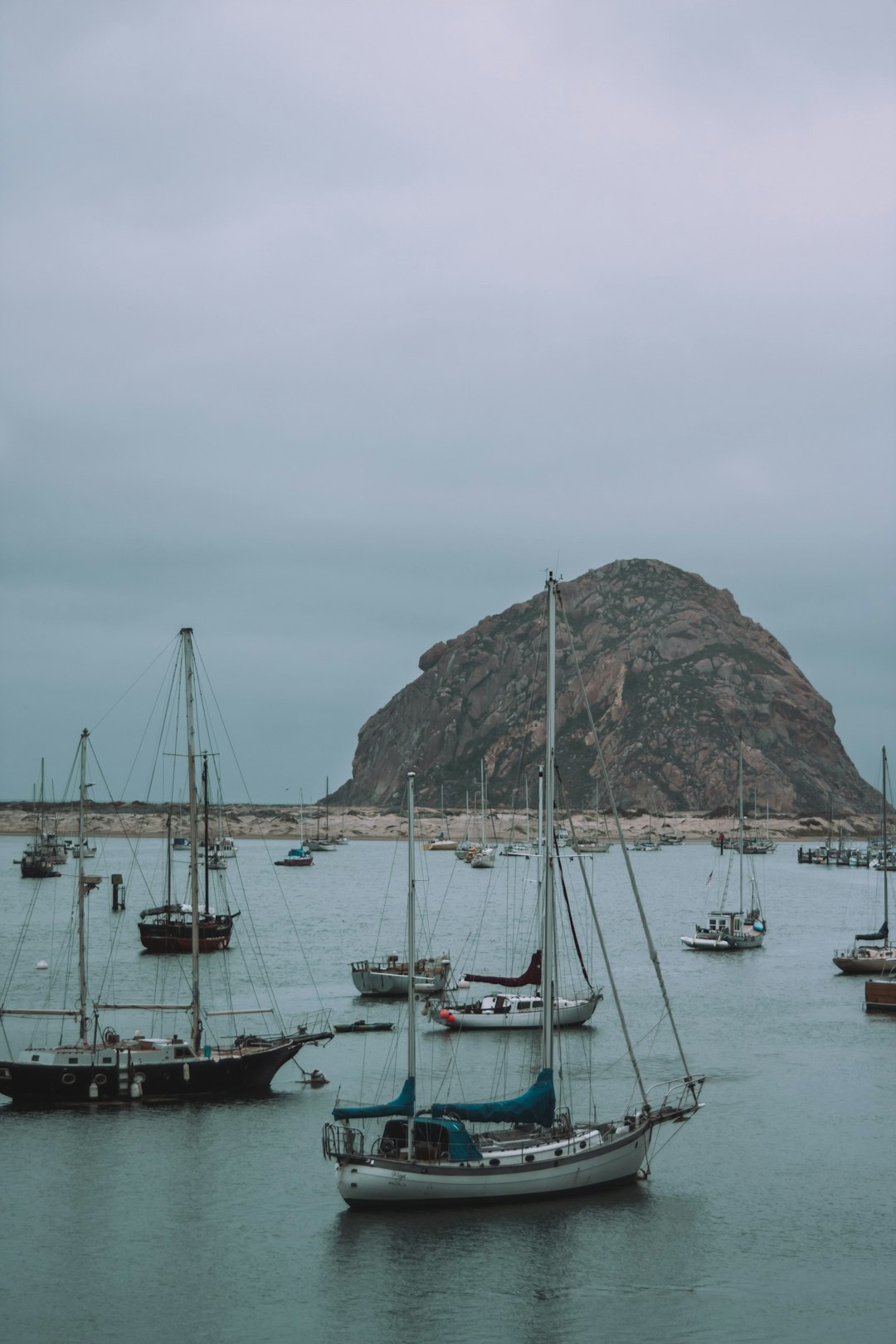 white and black boat on sea near mountain during daytime