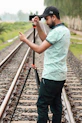 a man standing on a train track holding a camera