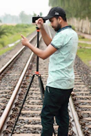 a man standing on a train track holding a camera