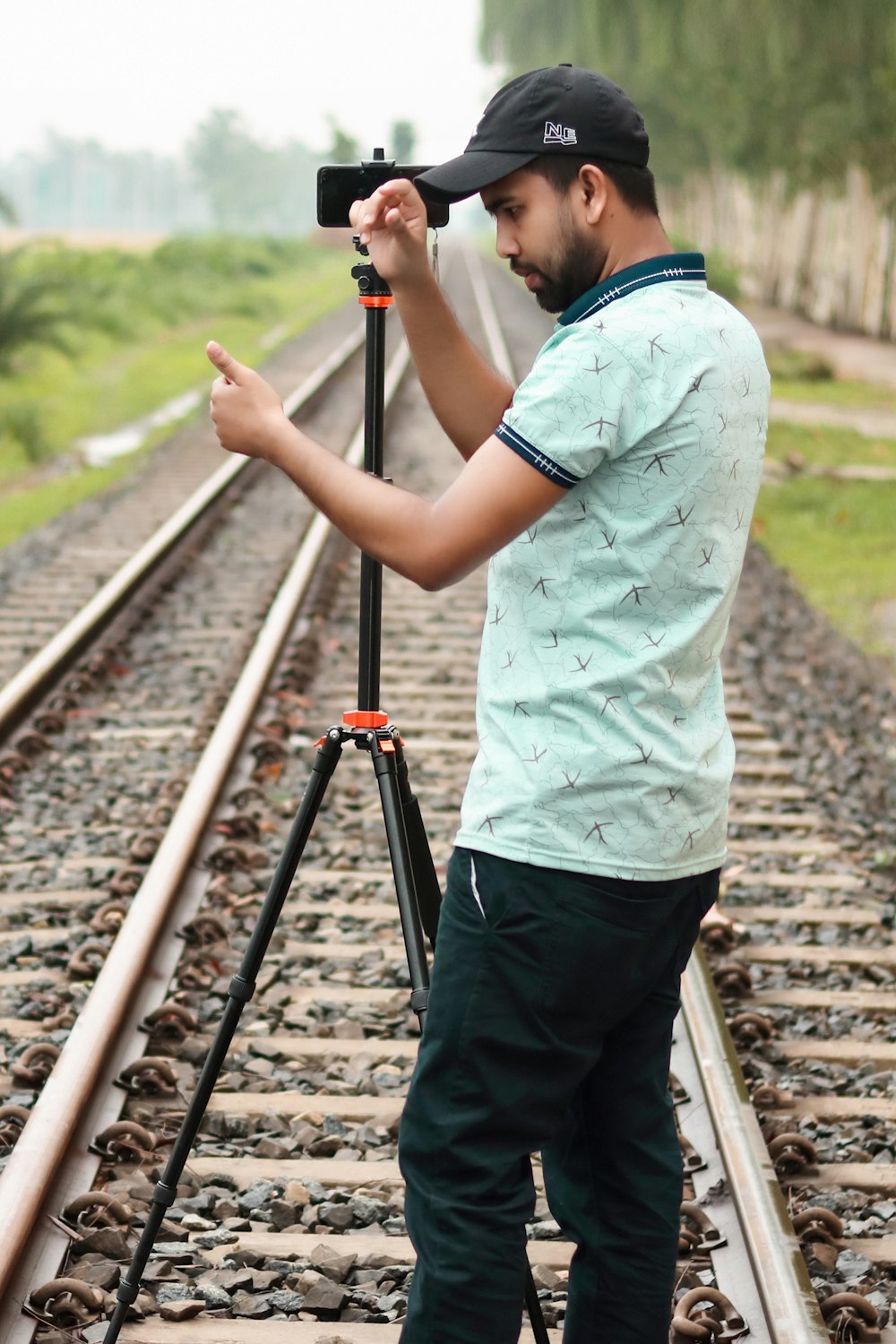 a man standing on a train track holding a camera