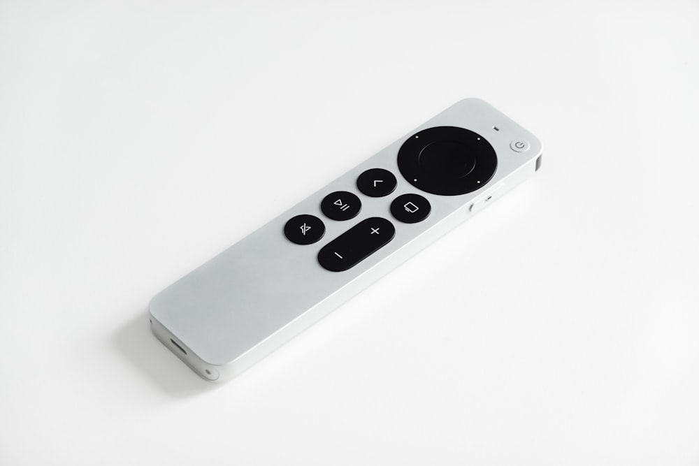 silver apple remote control on white surface