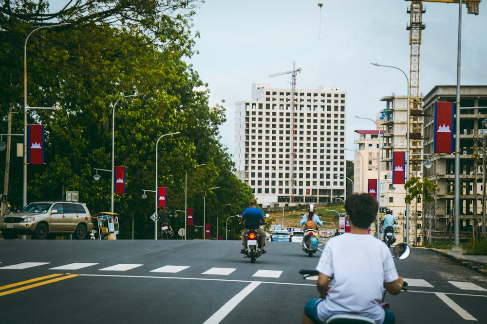 a group of people riding motorcycles down a street