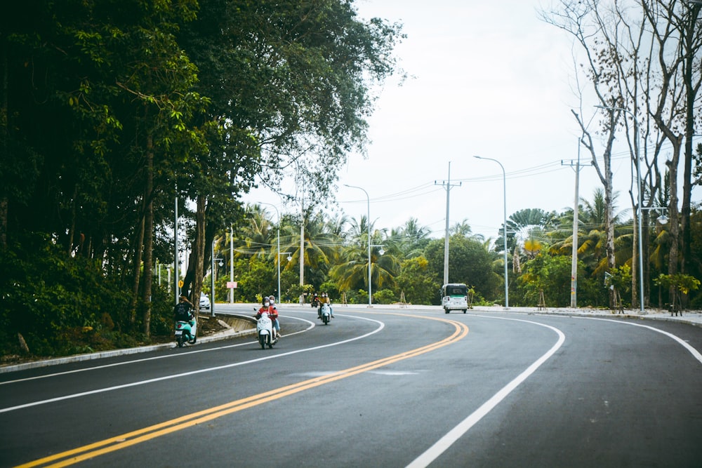 a group of people riding motorcycles down a curvy road