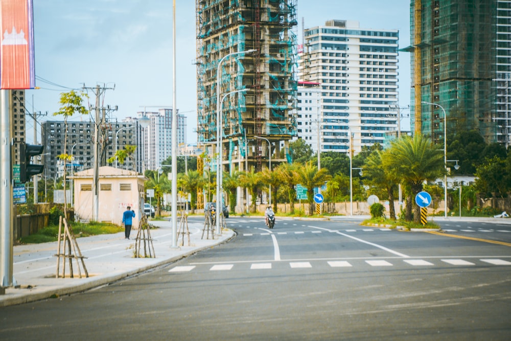 a city street with tall buildings in the background