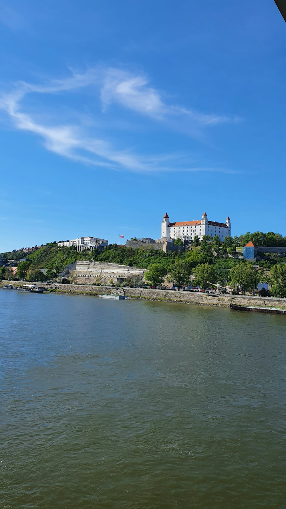 a body of water with a building on a hill in the background